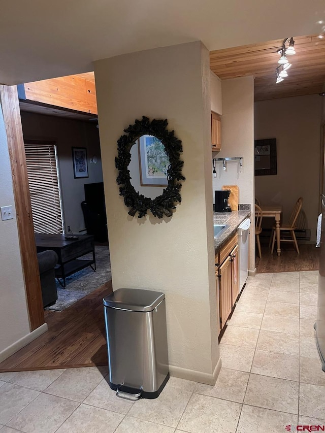 kitchen with light tile patterned flooring and stainless steel dishwasher