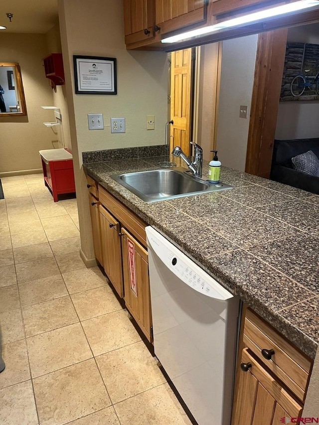 kitchen with dishwasher, light tile patterned floors, and sink