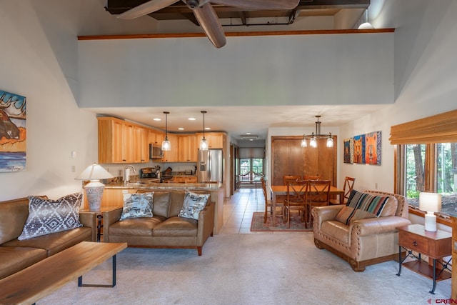 carpeted living room featuring beamed ceiling, a towering ceiling, ceiling fan with notable chandelier, and sink