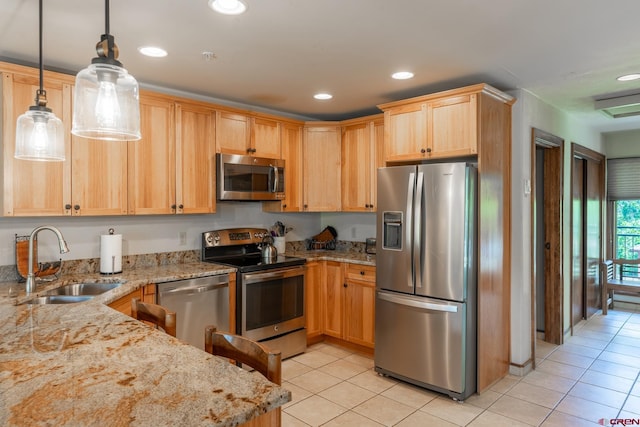 kitchen with light stone countertops, stainless steel appliances, sink, pendant lighting, and light tile patterned floors