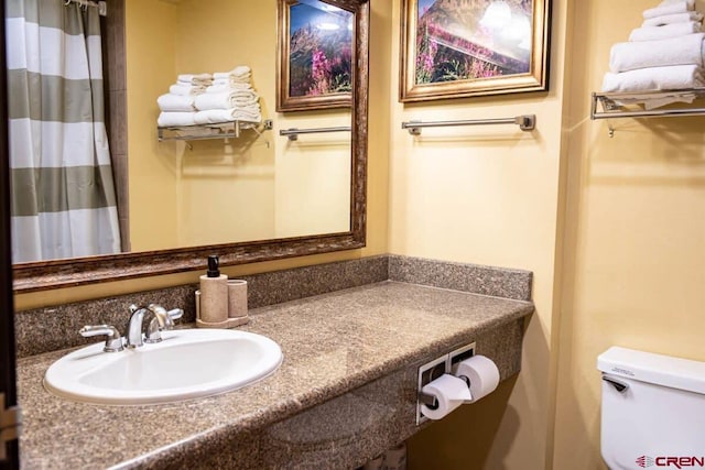 bathroom with curtained shower, sink, and toilet