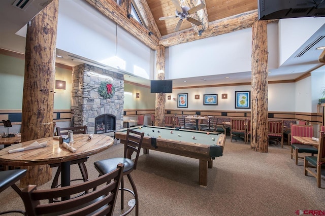 game room with high vaulted ceiling, a stone fireplace, carpet flooring, ornate columns, and pool table