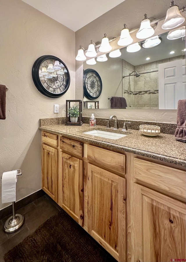 bathroom featuring a tile shower and vanity