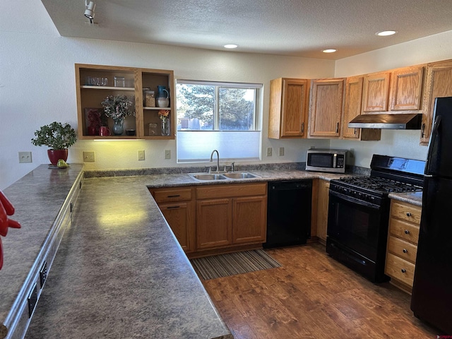 kitchen with kitchen peninsula, a textured ceiling, sink, black appliances, and dark hardwood / wood-style floors