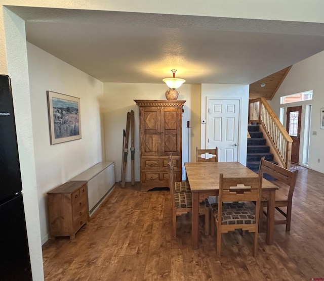 dining area with dark hardwood / wood-style flooring and a textured ceiling