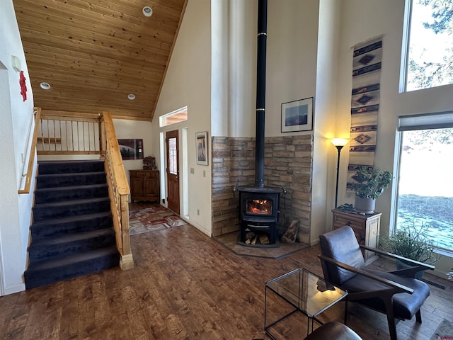 living room featuring dark hardwood / wood-style flooring, a wood stove, high vaulted ceiling, and wooden ceiling