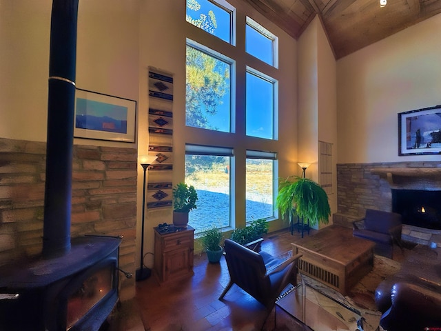 living room featuring hardwood / wood-style floors, wood ceiling, high vaulted ceiling, and a wood stove