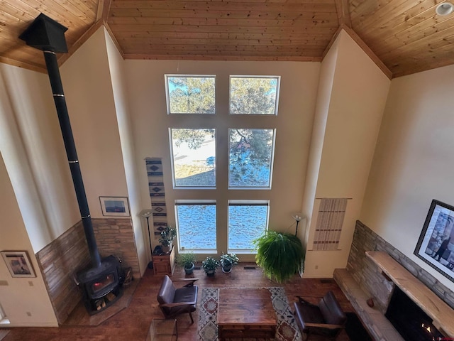 living room with a wood stove, a healthy amount of sunlight, a towering ceiling, and wood ceiling