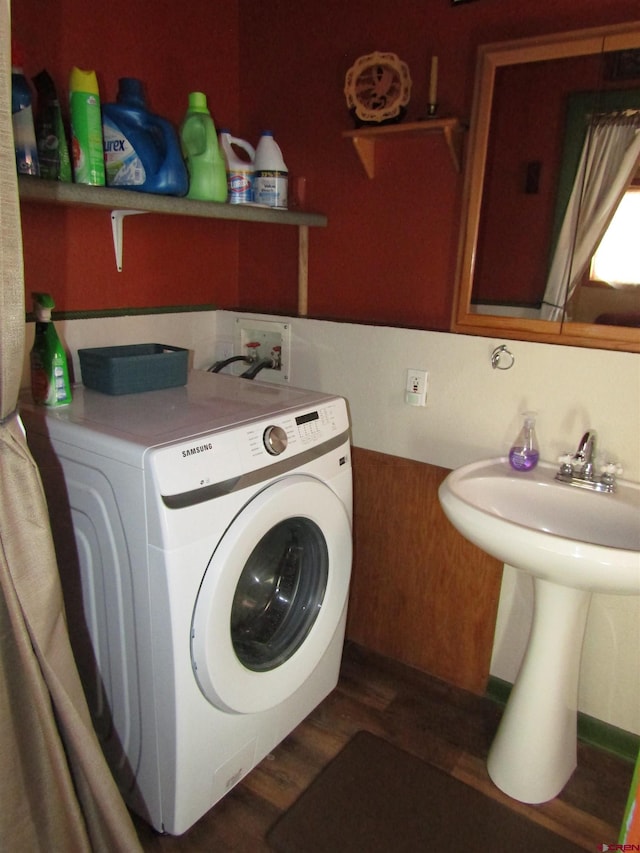 laundry area featuring dark hardwood / wood-style flooring, washer / clothes dryer, and wooden walls