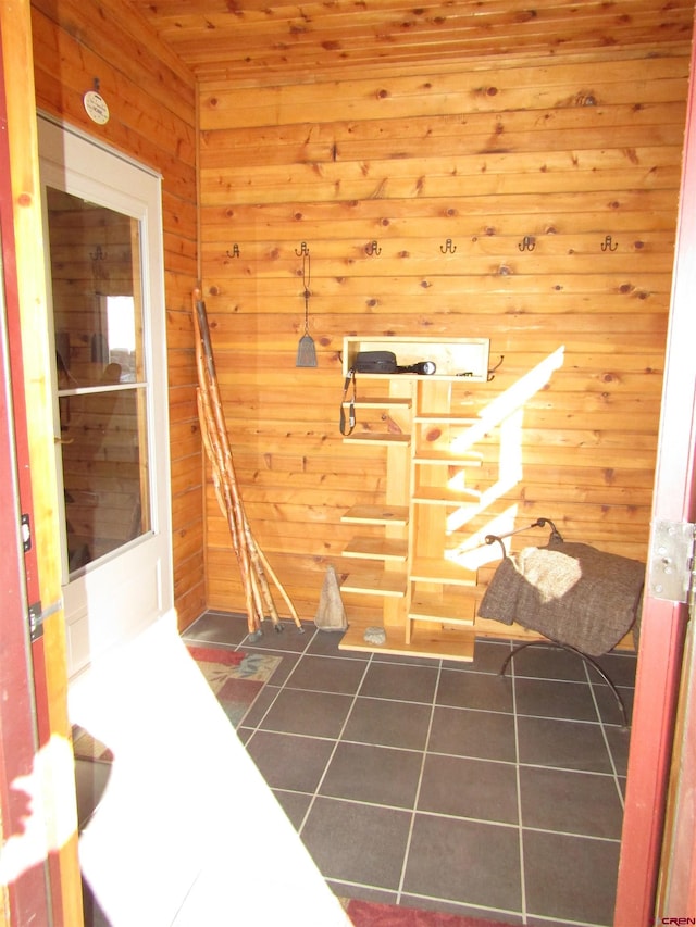 bathroom with tile patterned floors and wood walls