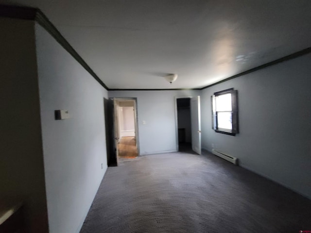 empty room featuring carpet floors, crown molding, and a baseboard heating unit