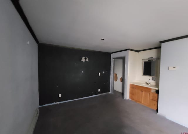 unfurnished bedroom featuring ornamental molding, sink, and ensuite bath