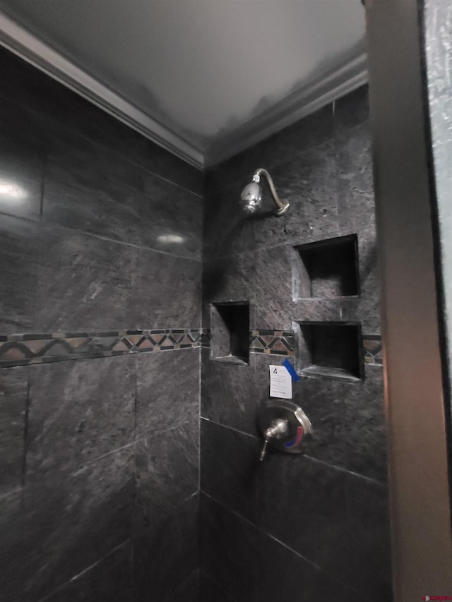 bathroom with crown molding and tiled shower