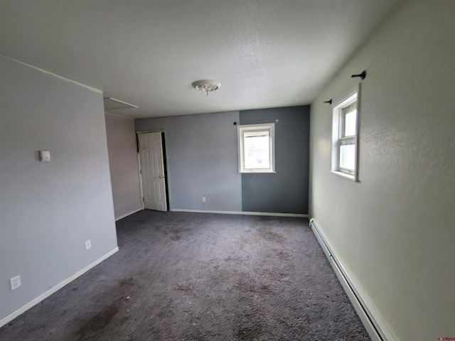 unfurnished room with carpet floors and a baseboard heating unit