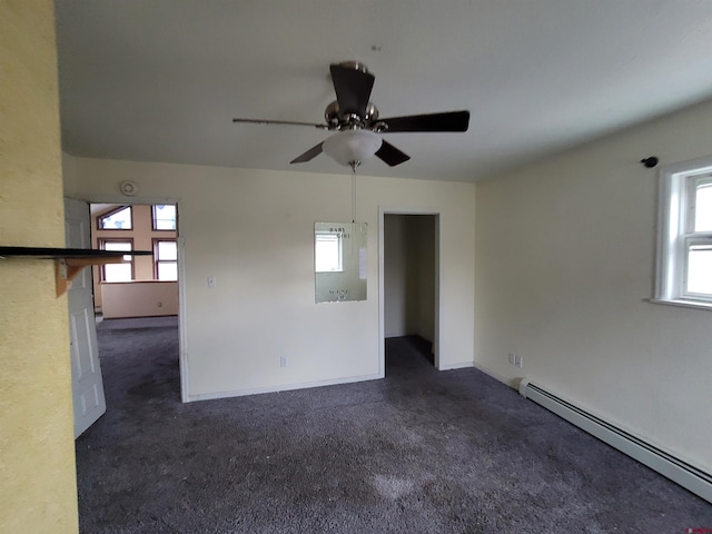 carpeted spare room with ceiling fan and a baseboard heating unit