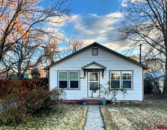 bungalow-style home with a front yard