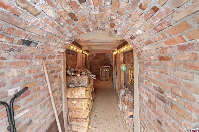 hallway featuring brick wall and brick ceiling