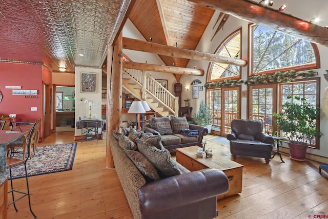 living room with high vaulted ceiling, beam ceiling, and light hardwood / wood-style floors