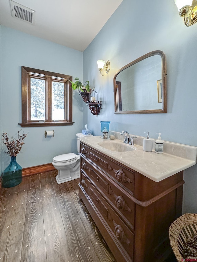 bathroom featuring toilet, wood-type flooring, and vanity