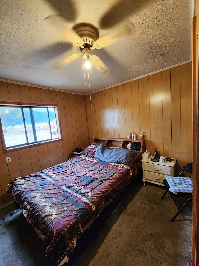 bedroom with a textured ceiling, wood walls, ceiling fan, and carpet