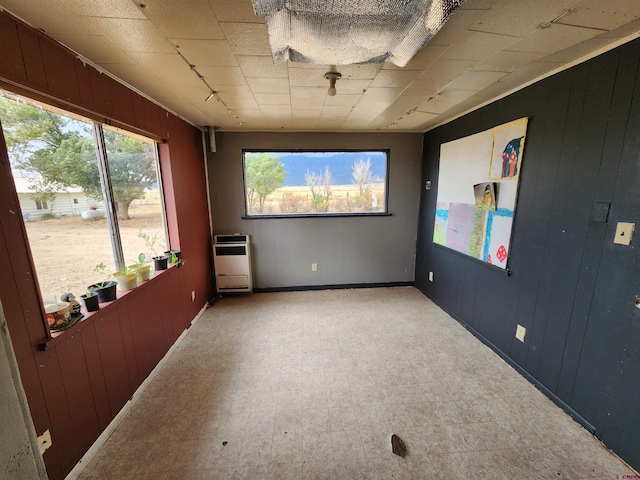 empty room featuring wood walls and heating unit