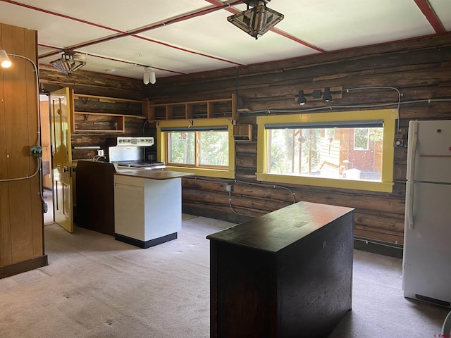 kitchen featuring white fridge, light carpet, log walls, and a center island