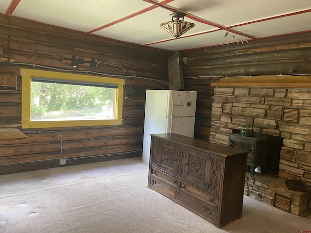 unfurnished office featuring light carpet and a wood stove