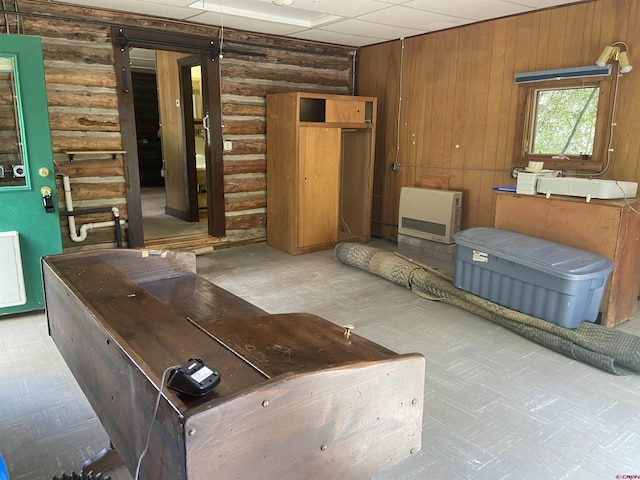 unfurnished living room featuring log walls and heating unit