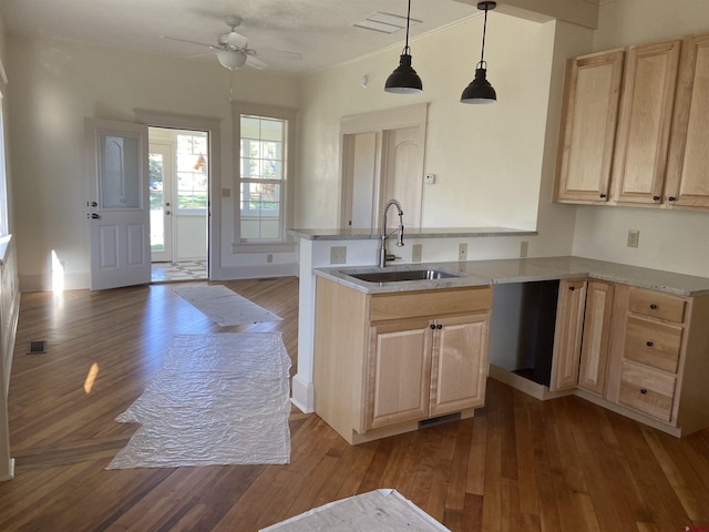 kitchen featuring sink, light brown cabinets, ceiling fan, and hanging light fixtures