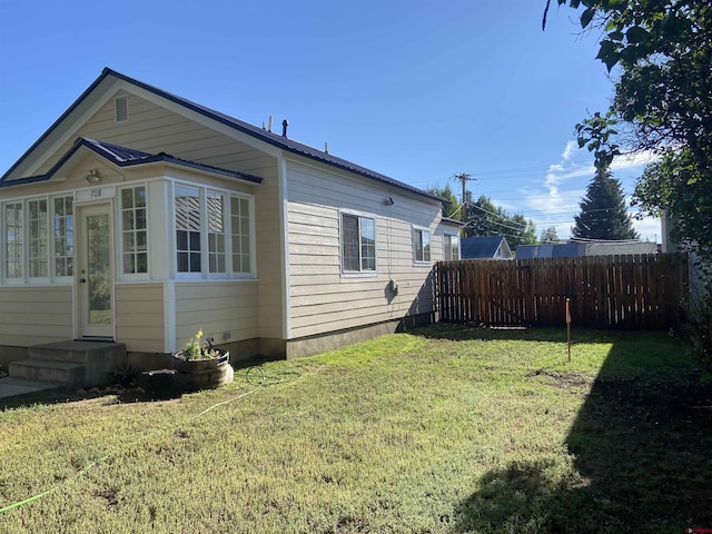 view of side of home with a lawn