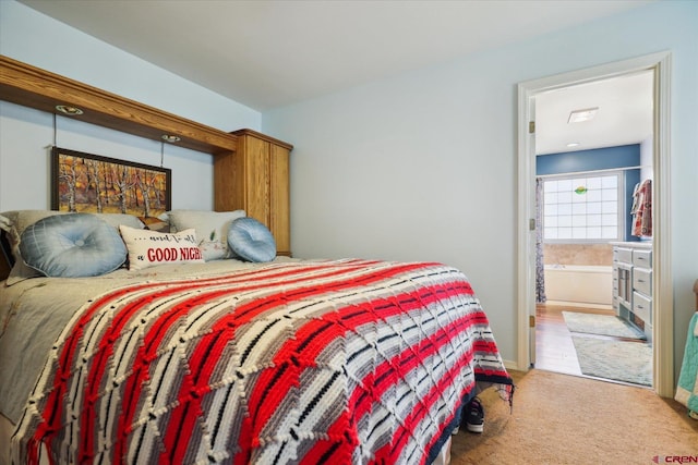 carpeted bedroom featuring ensuite bath