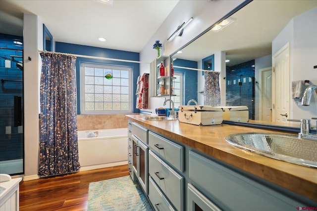 bathroom featuring shower with separate bathtub, wood-type flooring, and vanity