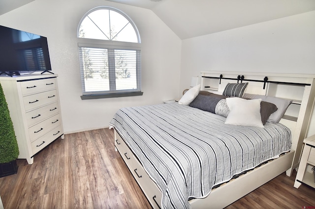 bedroom with wood-type flooring and vaulted ceiling