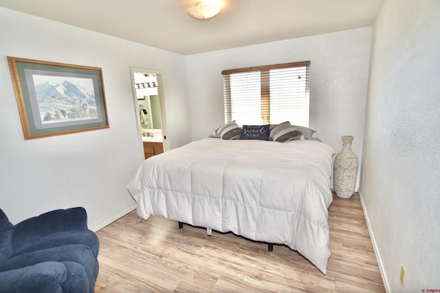 bedroom featuring light hardwood / wood-style floors and ensuite bathroom