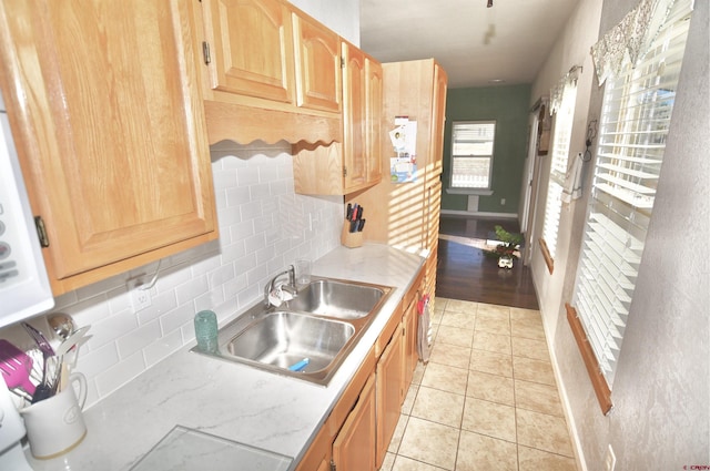 kitchen with sink, light tile patterned flooring, and tasteful backsplash