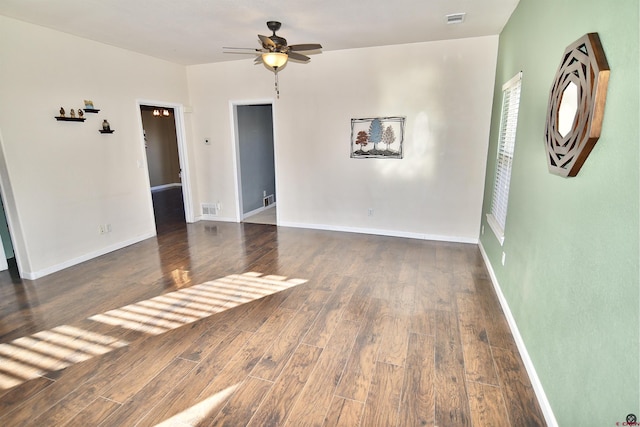 empty room featuring dark wood-type flooring and ceiling fan