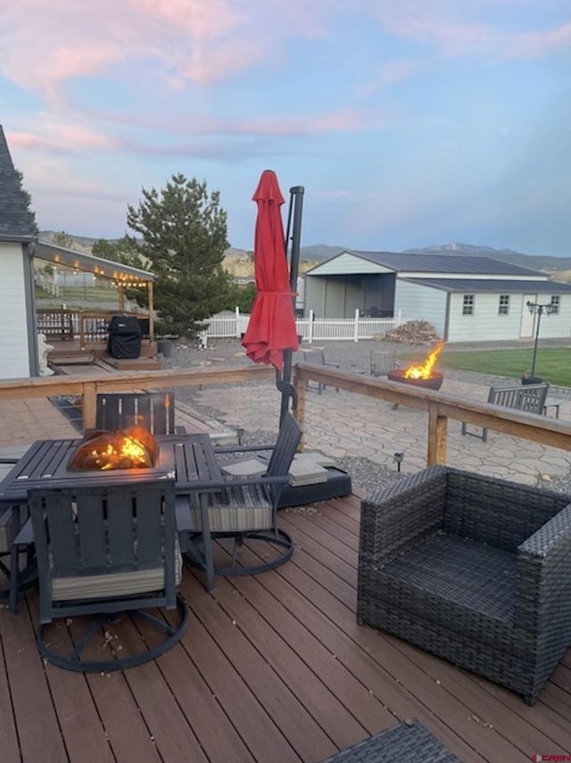 deck at dusk featuring a fire pit