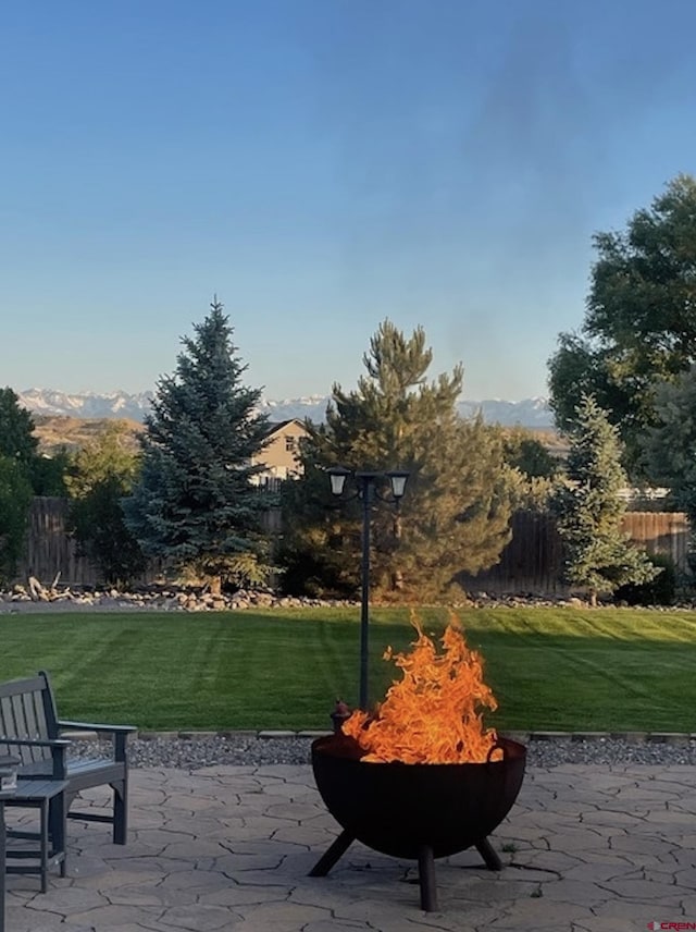 view of home's community with an outdoor fire pit, a patio, and a yard