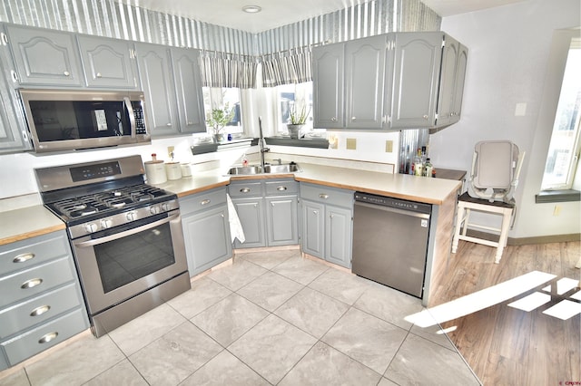 kitchen featuring appliances with stainless steel finishes, sink, and light tile patterned floors