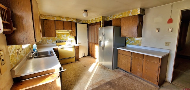 kitchen with stainless steel refrigerator with ice dispenser, sink, and electric range