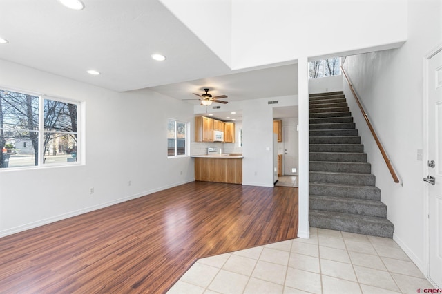 unfurnished living room featuring ceiling fan and light tile patterned flooring