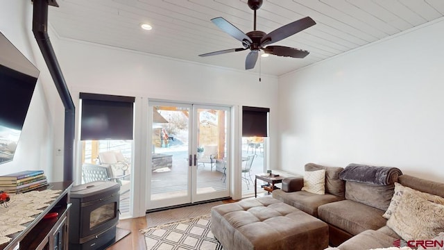 living room with ornamental molding, wooden ceiling, ceiling fan, and a wood stove