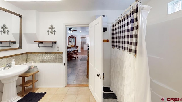 bathroom featuring curtained shower, tile patterned floors, tile walls, and ceiling fan