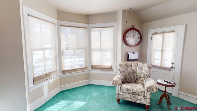 living area featuring lofted ceiling, carpet floors, and a wealth of natural light