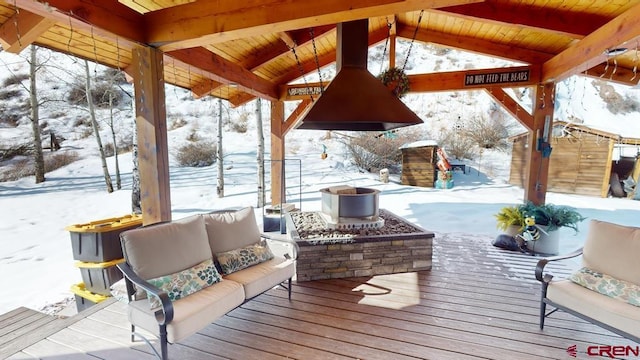 snow covered deck featuring outdoor lounge area and a gazebo