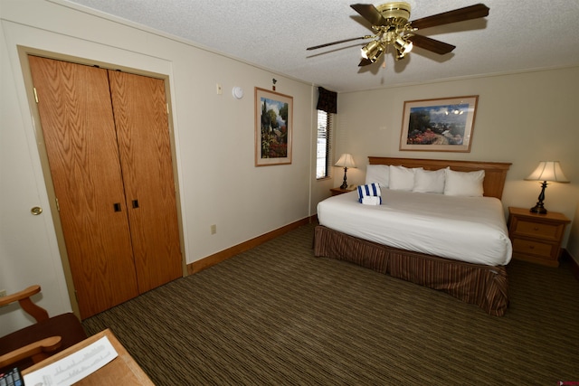 bedroom with a textured ceiling, ceiling fan, dark carpet, a closet, and crown molding