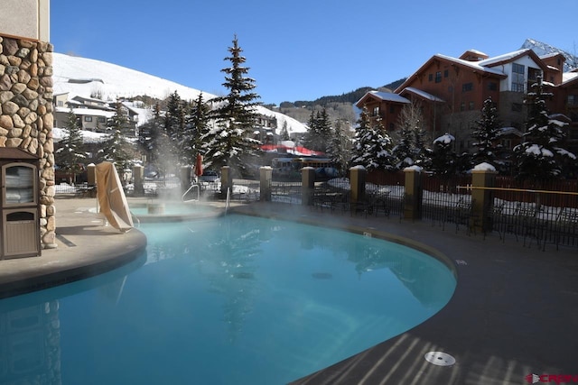 snow covered pool featuring a mountain view