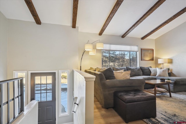 living room featuring lofted ceiling with beams and light hardwood / wood-style floors