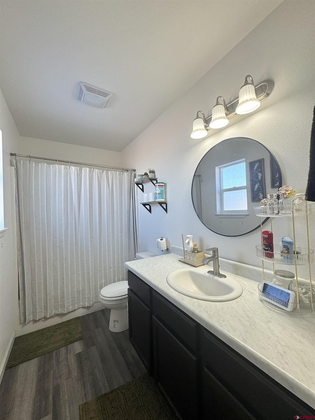 bathroom featuring toilet, hardwood / wood-style flooring, a shower with shower curtain, and vanity