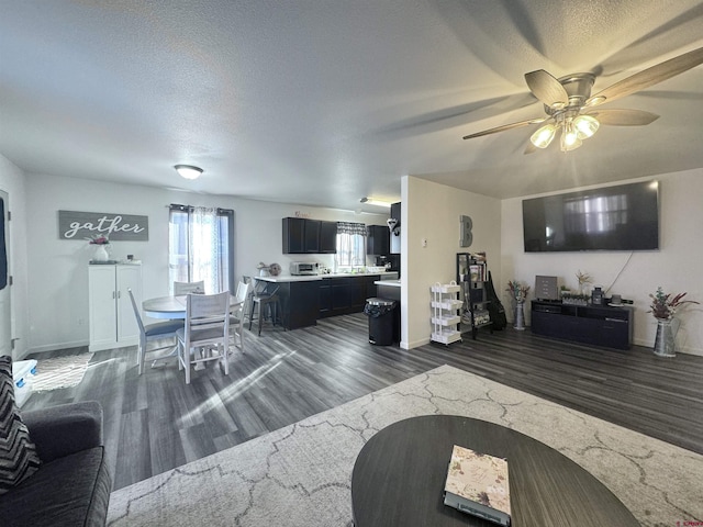 living room with dark wood-type flooring, a textured ceiling, and ceiling fan